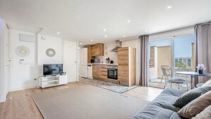 Un appartement moderne comprenant un salon, une cuisine et un balcon.