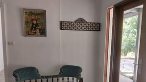 A room with a teal upholstered bench, a framed painting, and a decorative wall piece. - Private cottage on 40 acres with private creek and spectacular views.  (Eden Creek)