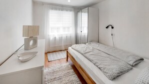A minimalist bedroom with a bed, bedside table, lamp, and a mirror. - Awesome home in Vittsjö with WiFi (Vittsjö)