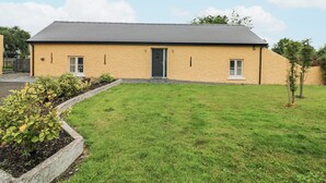 A single-story building with a flat roof, a front door, and two windows on the side. - THE FARM COTTAGE, family friendly in Athy, County Kildare (Athy)