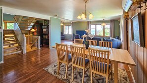 A spacious living area with a wooden dining table and chairs, a blue sofa, and a staircase leading to a lower level. - Nice home in åsgårdstrand (Åsgårdstrand)