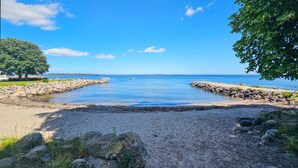 A beach with a rocky shoreline, a clear blue sky, and a calm sea. - Nice home in åsgårdstrand (Åsgårdstrand)