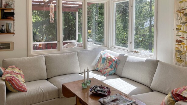 A cozy living room with a beige sofa, a wooden coffee table, and a window with a view of greenery. - Awesome home in Gräddö with WiFi (Gräddö)