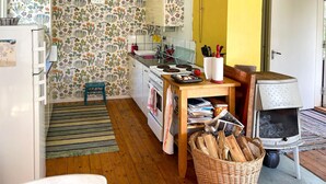 A kitchen with a stove, sink, and a basket of firewood. - Awesome home in Gräddö with WiFi (Gräddö)