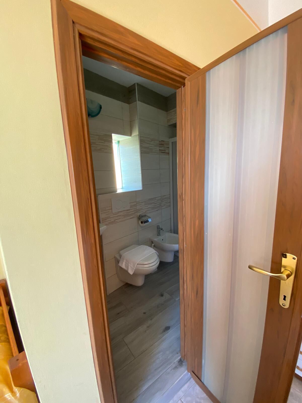 Une salle de bain avec des toilettes, un bidet et une fenêtre.