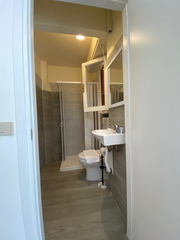 Un baño moderno con ducha, inodoro y lavabo.