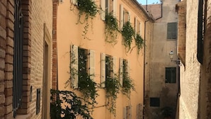 A narrow cobblestone street flanked by historic buildings with shuttered windows and a brick facade. - B&B Miramare Grottammare (Grottammare)