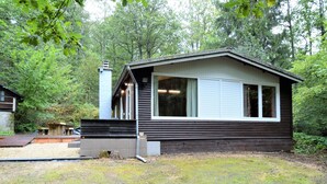A single-story cabin with a sloped roof, large windows, and a small porch area. - Cozy Chalet With Barbecue (Viroinval)
