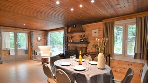 A dining area with a round table set for four, surrounded by chairs. - Cozy Chalet With Barbecue (Viroinval)