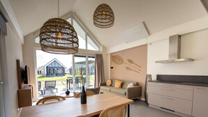 A modern kitchen with a dining area, large windows, and a view of the outside. - Modern Lodge by the Water (Breskens)