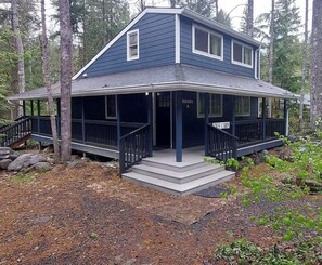 A two-story house with a porch and a staircase leading to the entrance. - Pet friendly cabin with WiFi, AC and workspace in gorgeous Mount Hood Village (Mount Hood Village)