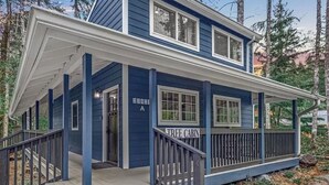 A blue cabin with a porch and steps, labeled "TREE CABIN."