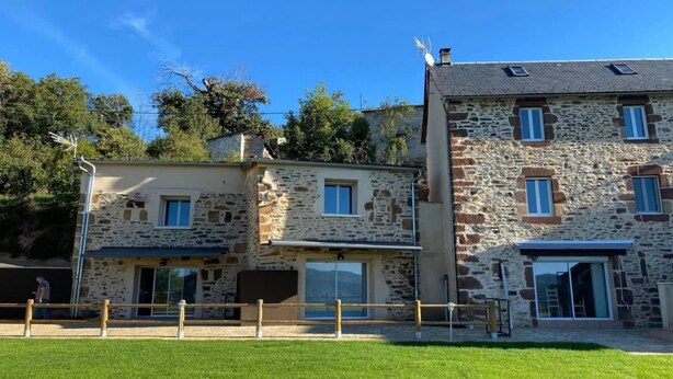 A stone building with multiple windows and a flat roof.