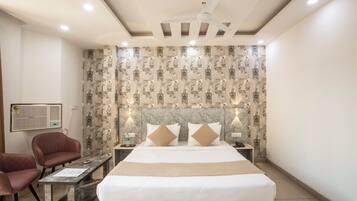 A hotel room with a bed, two nightstands, a desk, a chair, and a ceiling fan.