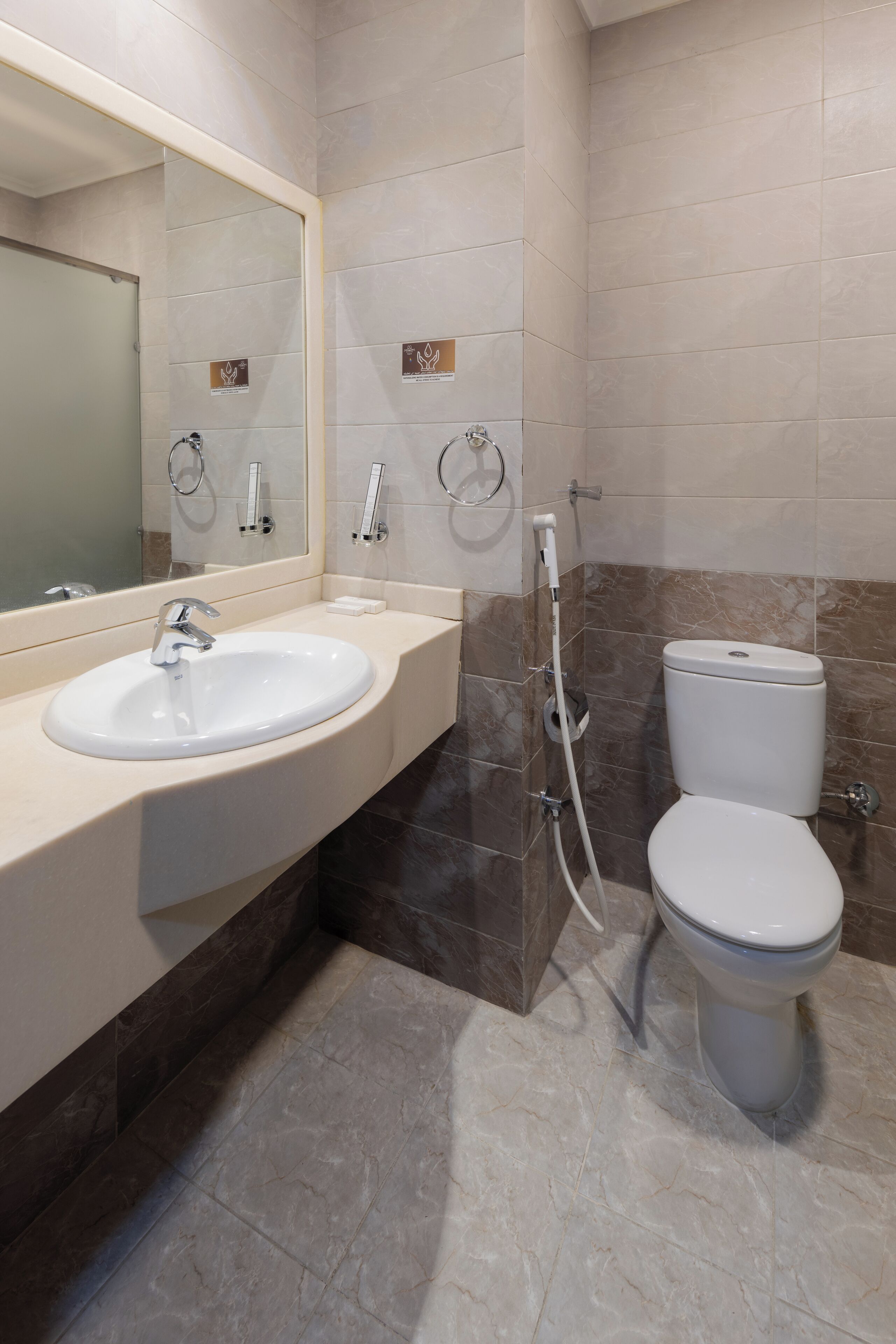 A modern bathroom with a sink, mirror, toilet, and shower.