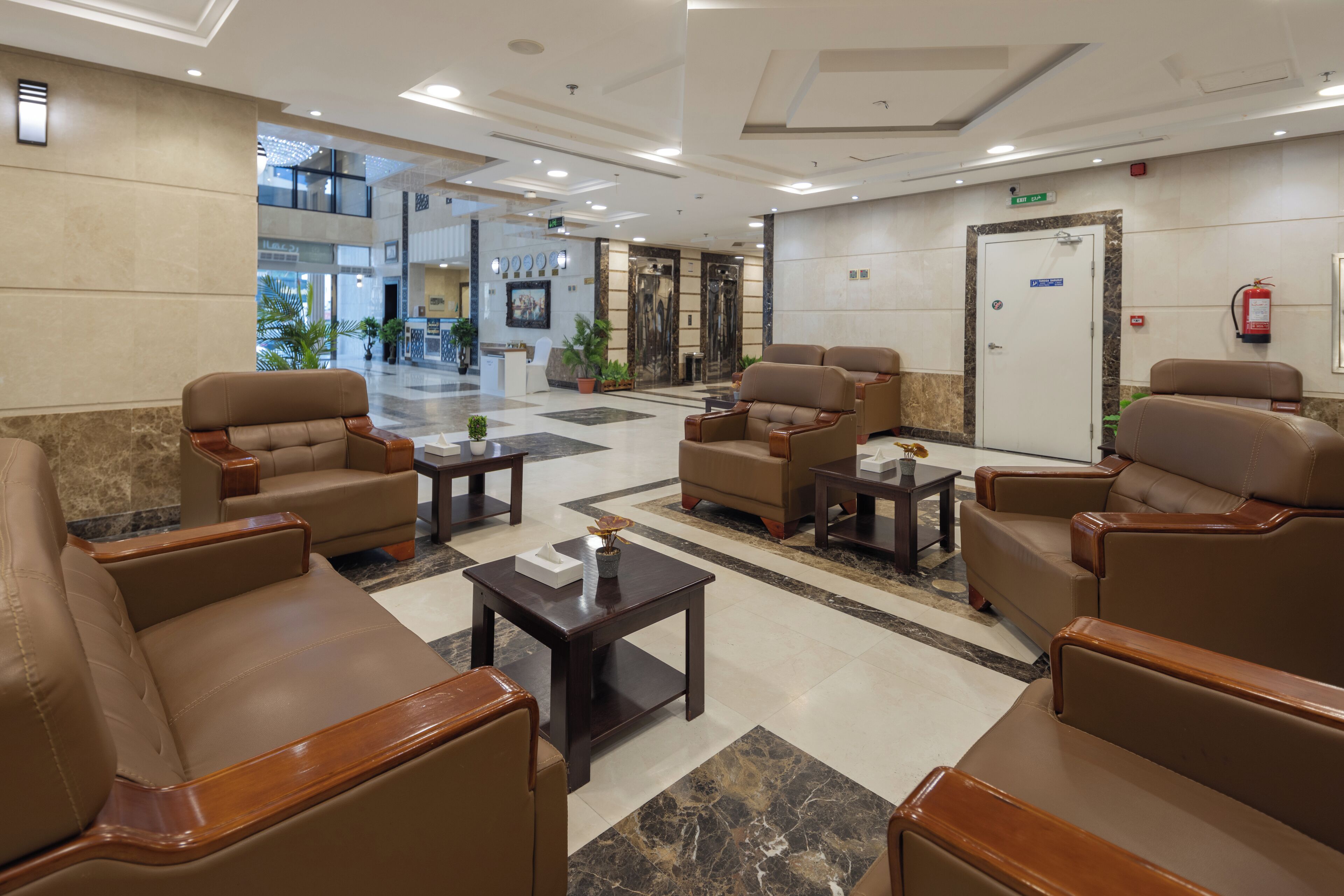 Aulassa on nahkasohvia, vastaanottotiski ja seinällä palosammutin.