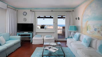 Departamento Confort, vista al mar | Área de sala de estar | Televisión de 30 pulgadas con canales vía satélite