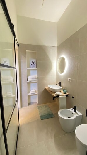 Een douche, een haardroger, een bidet, handdoeken