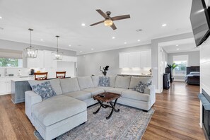A modern living room with a sectional sofa, a coffee table, and a ceiling fan. - Charming 4-bedroom house with AC and WiFi in lovely Arabi (Arabi)