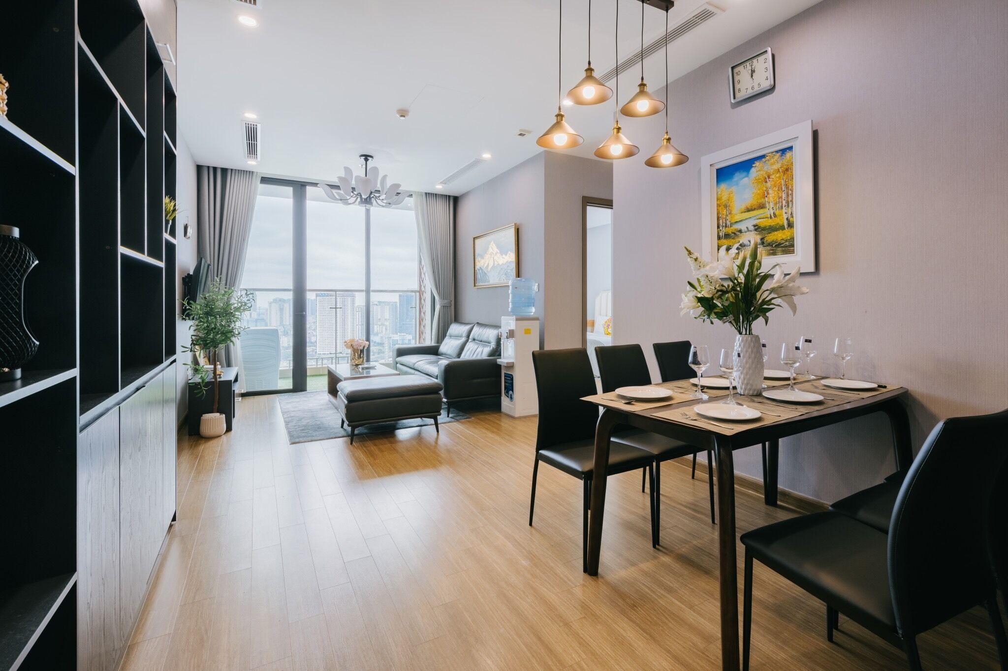 Una sala de estar moderna con comedor, ventanas amplias y vistas a la ciudad.