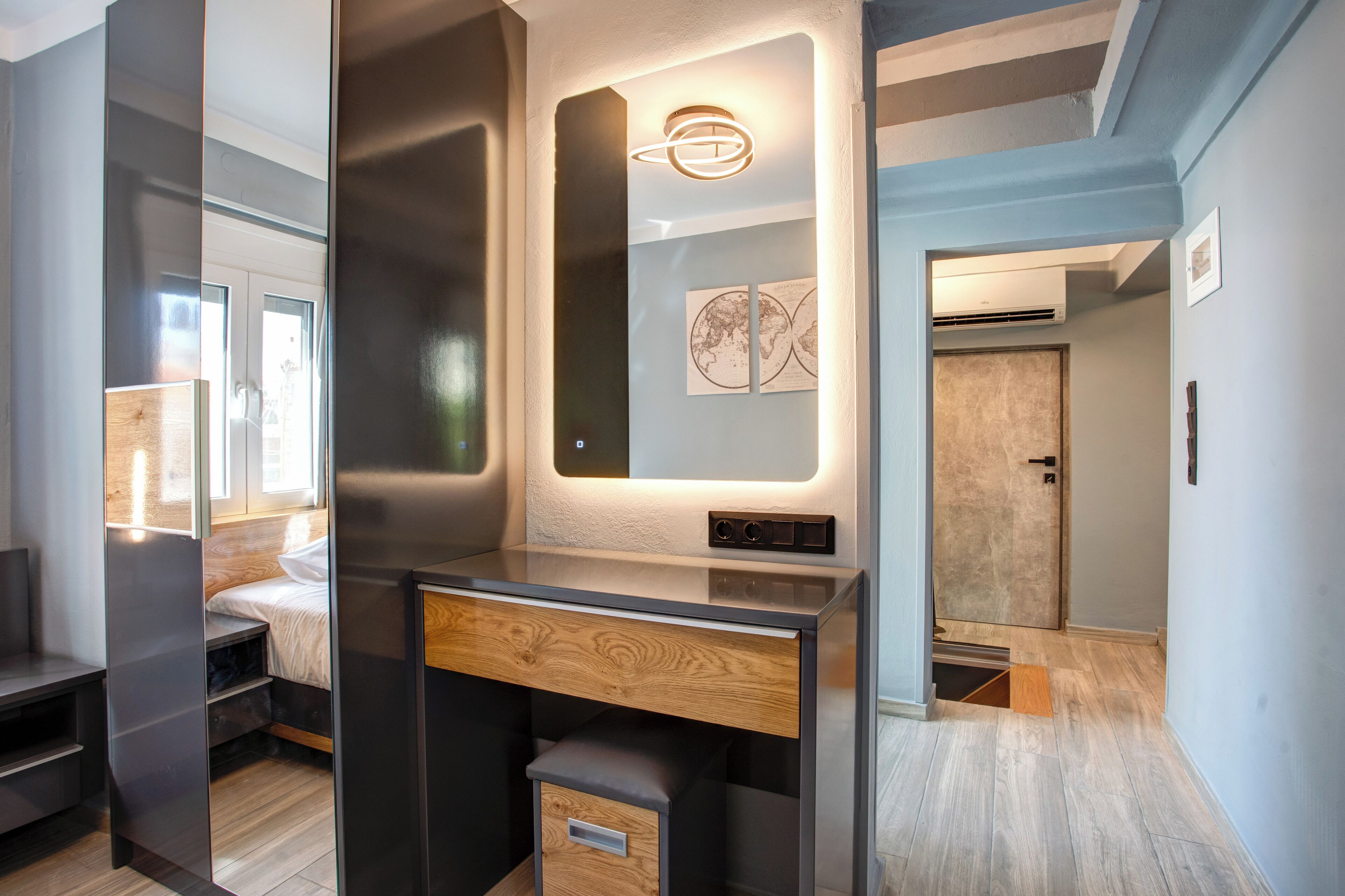 Um quarto moderno com cama, escrivaninha e guarda-roupa.