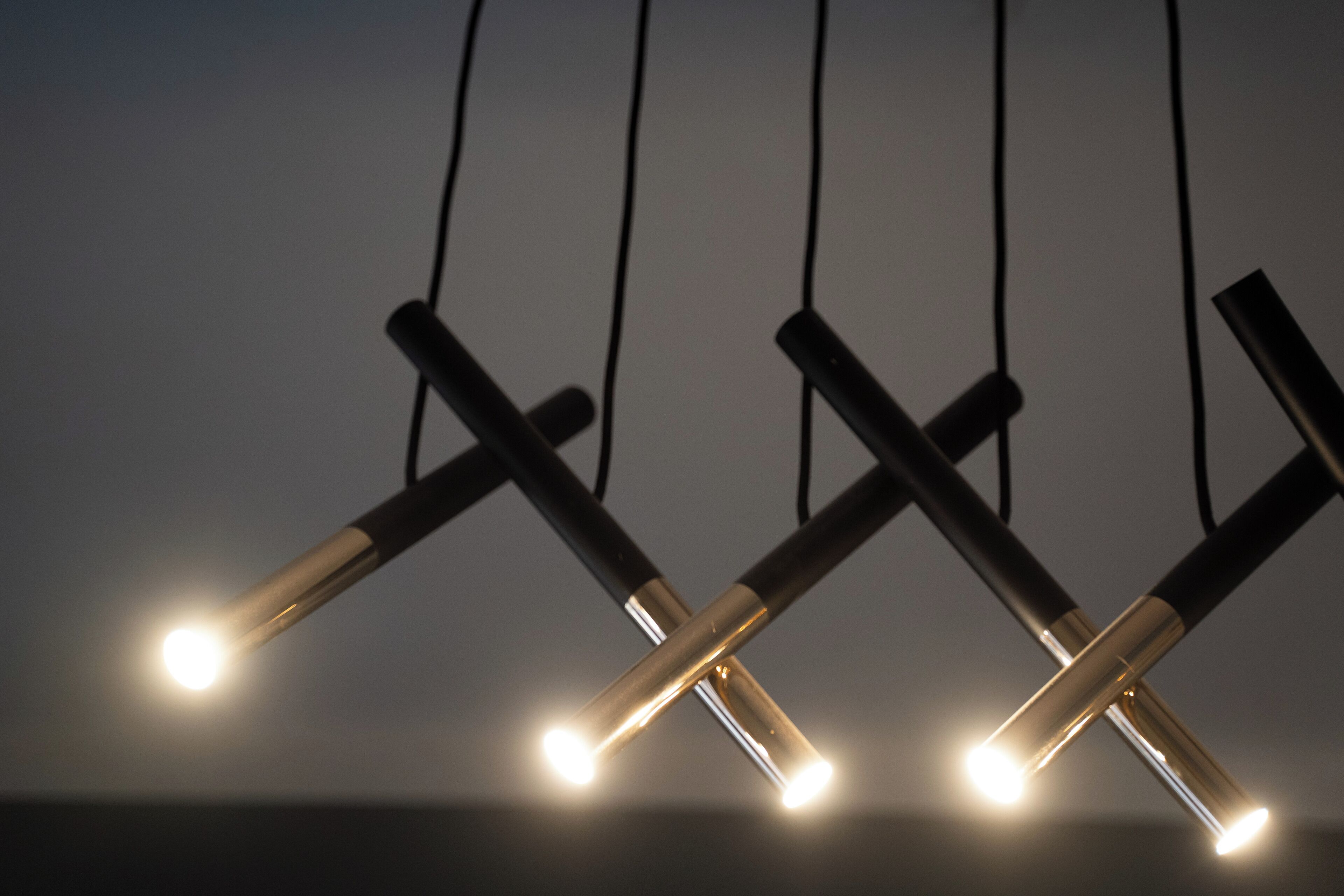 A close-up of four hanging light fixtures with exposed bulbs.