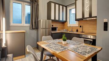 A modern kitchen with wooden cabinets, a built-in oven, and a dining area with a wooden table and chairs.