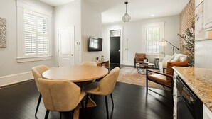 A modern living room with a dining area, a kitchen with granite countertops, and a fireplace. - 4BR House | City Views | Balconies | Walk to OTR (Cincinnati)