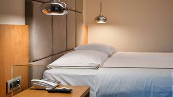 Een hotelkamer met een bed, nachtkastje en telefoon.
