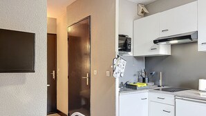 A compact kitchen with white cabinets, a microwave, and a stove.