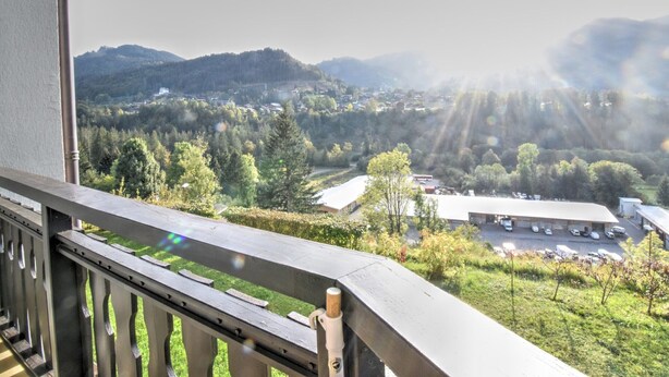 A balcony with a view of a town, mountains, and a parking lot. - Studio in Morzine, near slopes, balcony, parking, 4 pers (Morzine)