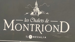Señalización para 'les Chalets de Montriand' de Nexalia, con una ilustración de una montaña y un edificio.