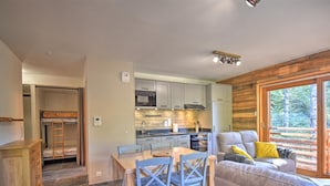 Un espacio habitable compacto con kitchenette, comedor y sofá.