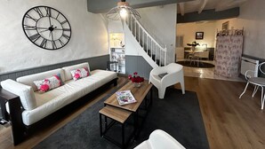 Un salon moderne avec un canapé, une table basse et un escalier menant à une autre pièce.