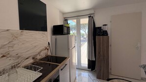 A compact kitchen with a marble countertop, a microwave, a refrigerator, and a coffee maker. - Cozy 2-Room Apartment with Pool, Tennis, and Parking Near Beach - Sleeps 6 (Fleury-Saint-Pierre-la-Mer)