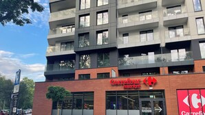 Un edificio de varios pisos con un mercado Carrefour en la planta baja.