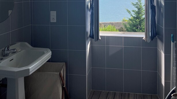 Ein Badezimmer mit Meerblick, einem Waschbecken und einem Spiegel.
