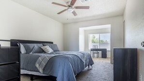 Ein Schlafzimmer mit Bett, Schreibtisch, Stuhl und Kleiderschrank.