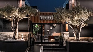 A modern building with a sign reading "THE GREY" at the entrance, surrounded by trees and a stone pathway. - The Grey Alaçatı (Cesme)