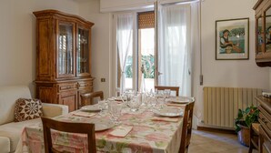 A dining area with a table set for four, a wooden cabinet, and a radiator. - Lovely apartment in Monteriggioni (Monteriggioni)