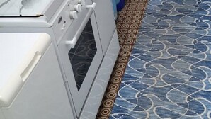 Eine Küche mit einem weißen Herd, Backofen und einer blauen Tür.