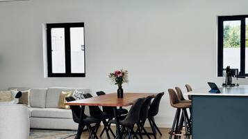 Un espace de vie moderne comprenant un coin repas, un canapé et un îlot de cuisine.