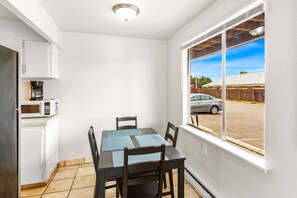 Enjoy meals at the dining table for four, with a microwave above and a cabinet nearby.