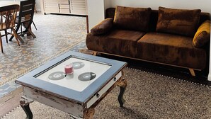 A living room with a sofa, a coffee table, and a TV mounted on the wall.