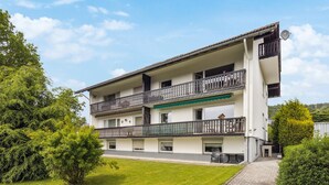 A two-story building with balconies, a paved driveway, and surrounding greenery. - Gorgeous apartment in Hildfeld with WiFi (Hildfeld)