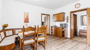 A room with a wooden dining table, chairs, a microwave, a cabinet, and a clock on the wall. - Gorgeous apartment in Hildfeld with WiFi (Hildfeld)