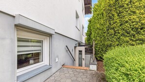 A modern building with a white exterior, a large window, and a small entrance with a door. - Gorgeous apartment in Hildfeld with WiFi (Hildfeld)