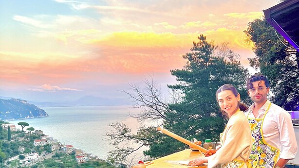 A balcony with a scenic view of the sea and a town in the background.