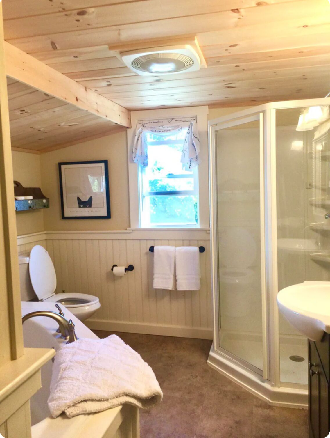 A bathroom with a toilet, sink, and shower.