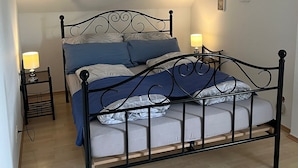 Una camera da letto con un letto, due comodini e un soffitto spiovente.